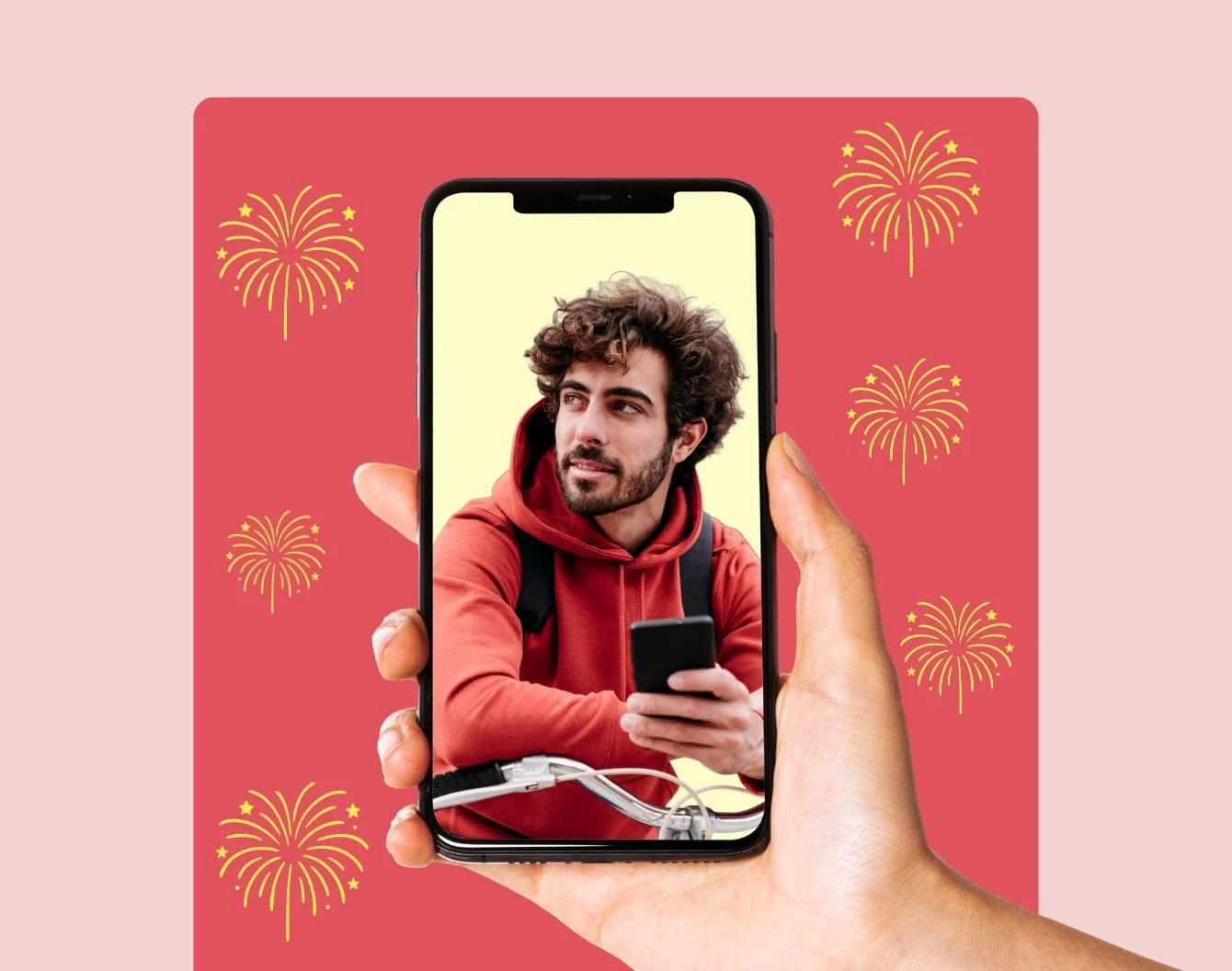 Small gold fireworks burst around a floating hand displaying a phone screen displaying a man on his phone on a medium pink rectangle against a light pink background.